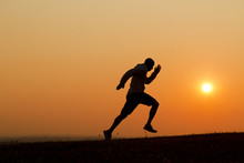 Sunset Silhouette Of A Man Running Uphill