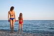 © Pavel Losevsky - Mother and daughter in swimsuit standing on beach