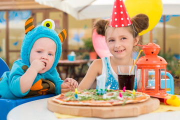 Boy in costumes of monsters and girl in festive cap