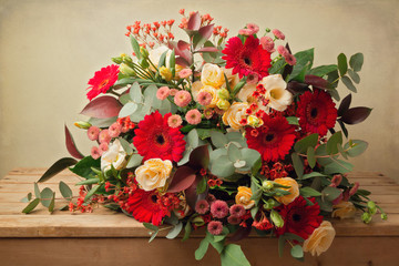 Beautiful flower bouquet on wooden table over grunge background