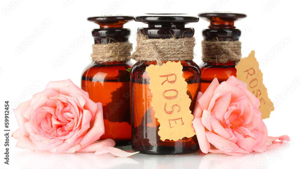 bottles of oil and roses isolated on white