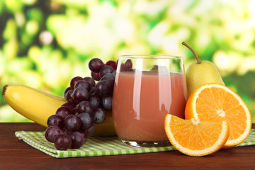 Wall Mural - Glass of fresh juice on table on bright background