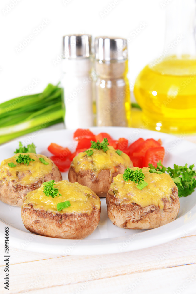 Stuffed mushrooms on plate on table on light background
