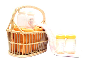 diapers milk bottle and flask in basket isolated on white backgr