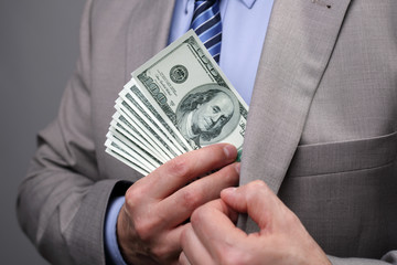 Businessman putting money in pocket