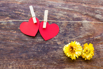 Valentine's day card with two red hearts symbol on a wooden  sur