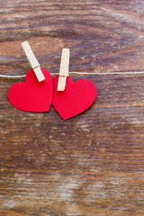 Valentine's day card with two red hearts symbol on a wooden  sur