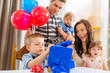 © Tyler Olson - Family Looking At Birthday Boy Opening Gift Box
