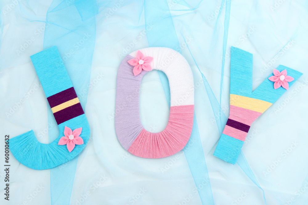 Word Joy created with brightly colored knitting yard