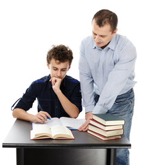 Father standing near son's desk helping him doing his homework