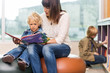 © Tyler Olson - Teacher With Boy Reading Book In Library