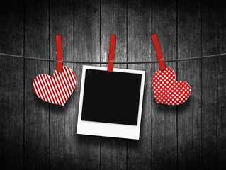 hearts hanging on clothesline over wooden background