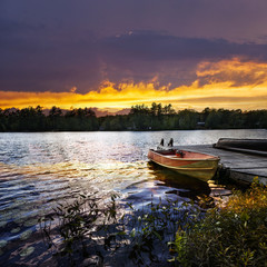 Canvas Print - Boat docked on lake at sunset