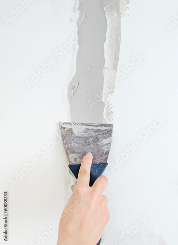 Fotografía Female hand repairs wall with spackling paste