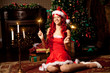 © Miramiska - Young beautiful smiling santa woman near the Christmas tree. Gir