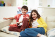 © Monkey Business - Two Hispanic Children Sitting On Sofa Watching TV Together
