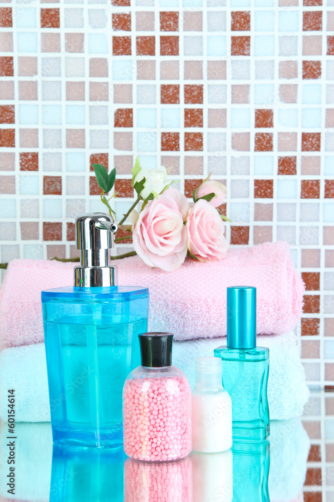 Cosmetics and bath accessories on mosaic tiles background