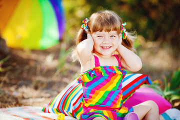 Adorable toddler girl playing outdoors in green summer park