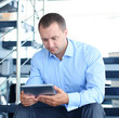 © ty - businessman sitting on stairs with electronic tablet