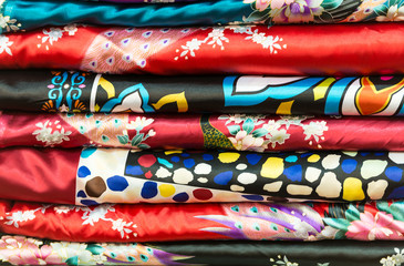 Pile of silk clothes with abstract asian design.