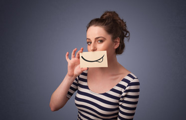 Pretty young girl holding white card with smile drawing