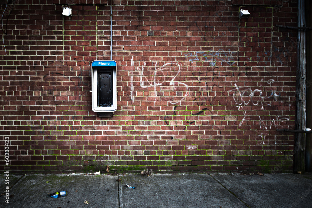Grungy urban  wall with an old payphone on it - obrazy, fototapety, plakaty 