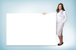 © adam121 - young woman doctor standing near a blank banner