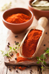 Wall Mural - red paprika powder spice in wooden scoop