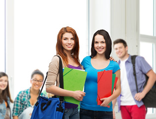 Canvas Print - two smiling students with bag and folders