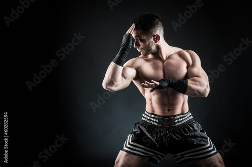 Obraz na płótnie canvas trzyczęściowy "tryptyk" Sportowiec kick bokser intensywny portret na czarnym tle.