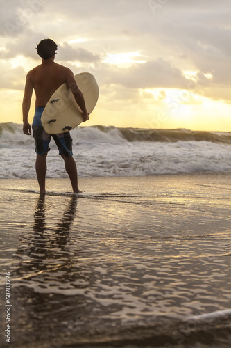 Obraz na płótnie canvas trzyczęściowy "tryptyk" Mężczyzna surfer i deska surfingowa zachód wschód plaża