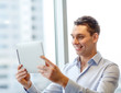 © Syda Productions - smiling businessman with tablet pc in office