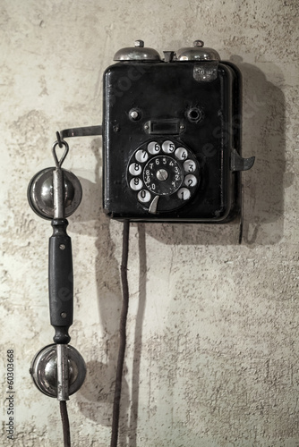 Obraz w ramie Vintage black phone hanging on old gray concrete wall