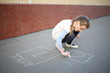 © Pavel Losevsky - The girl begins to draw hopscotch on the pavement