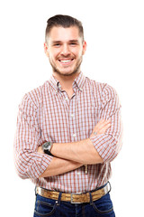 Wall Mural - Casual young man looking at camera with arms crossed