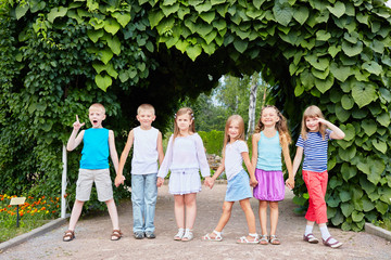 Children stand holding hands with their backs to tunnel