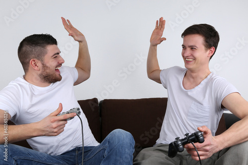 Junge Leute gewinnen beim Spielen auf Spielkonsole плакат