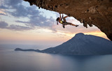 Fototapeta  - Young female rock climber at sunset, Kalymnos Island, Greece