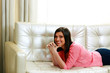 © Drobot Dean - Middle-aged cheerful woman lying on the sofa