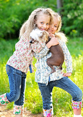 Wall Mural - Portrait of two little girls twins with a dog