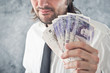 © Bits and Splits - Businessman holding British pounds money