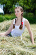 © stormy - Beautiful young woman sitting thoughtful on dry hay