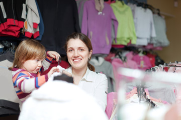 Poster -  Happy woman and child chooses clothes