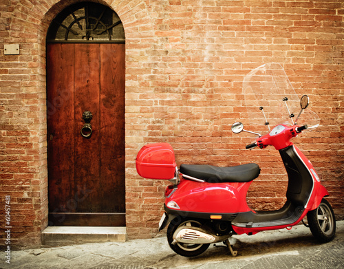 Naklejka ścienna Vintage image of red scooter on the street