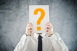 © Bits and Splits - Businessman holding paper with printed question mark