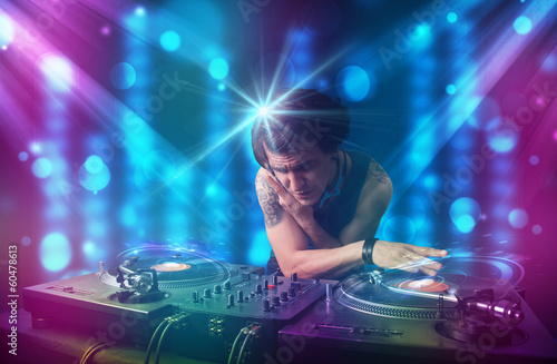 Plakat na papierze fotorealistycznym Dj miksowania muzyki w klubie z niebieskimi i fioletowymi światłami