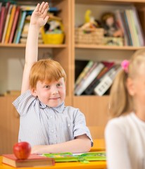 Fototapete - Children behind school desks during lesson