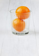 Juicy tangerines in glass on a white wooden surface