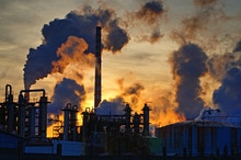 Chimneys And Dark Smoke Over Chemical Factory At Sunset