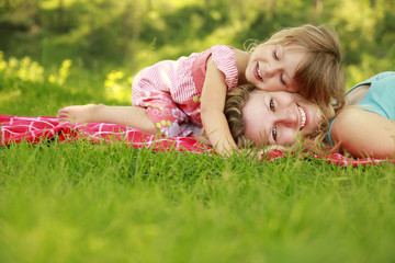 Mama and her little daughter on the grass